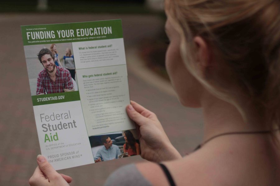 An AACC student reads the Federal Student Aid handbook to learn about the new FAFSA deadline.