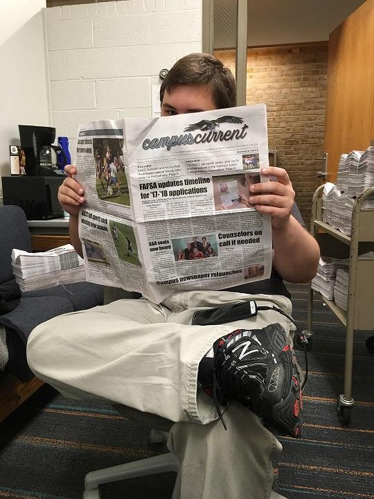 Editor Cody Colston reads the first print edition of the Campus Current in over a year.