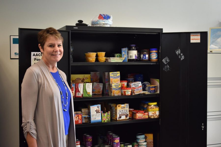 Director of Student Engagement Chris Storck stands beside the food pantry in her office; the pantry offers food to students who can’t afford meals.