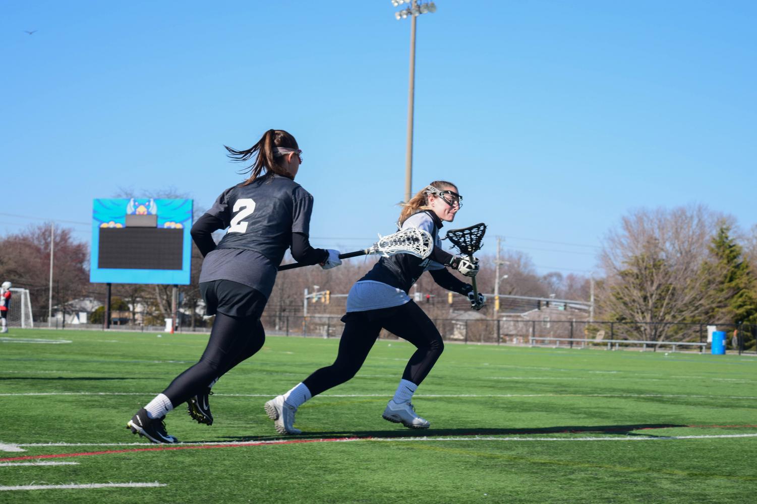 Lacrosse players Payton Baronella-O’Toole and MacKenzie Schwartz practice for a game. Some athletes will be able to count developmental courses in their GPAs next fall.