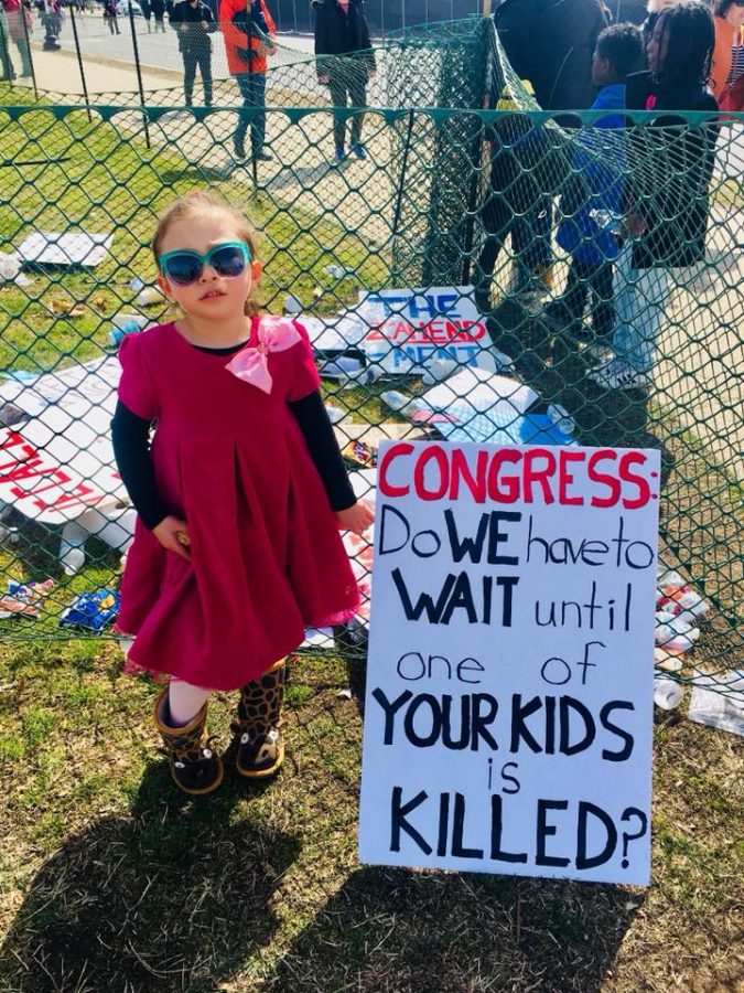 Five-year-old Yu-Mi Lee, who attends the campus Child Development Center, joins her mother, AACC librarian Mea Lee, at the march.