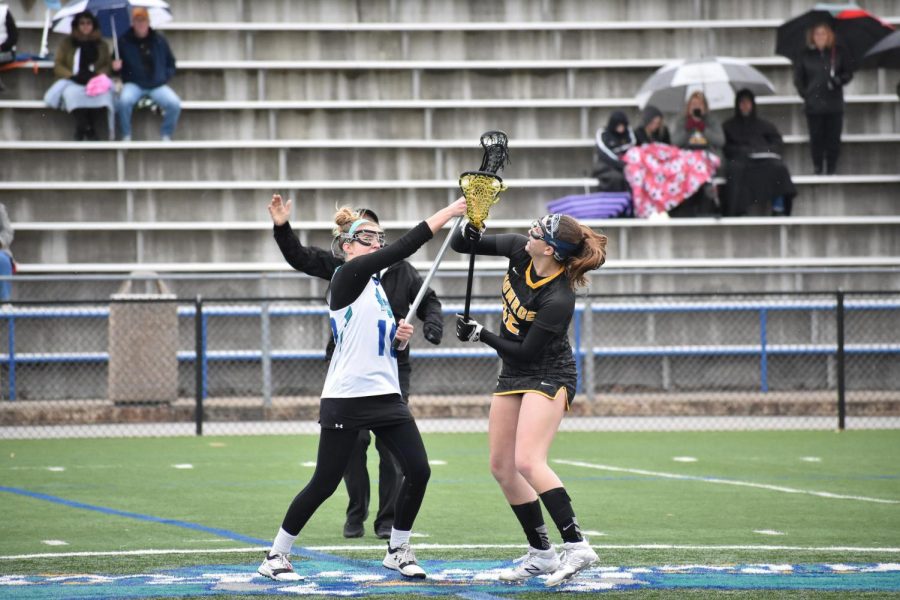 Defender Kara Steir (left), attack Caitlyn Shriver and goalie Deanna Valerien (right) prevent a Monroe player from scoring.