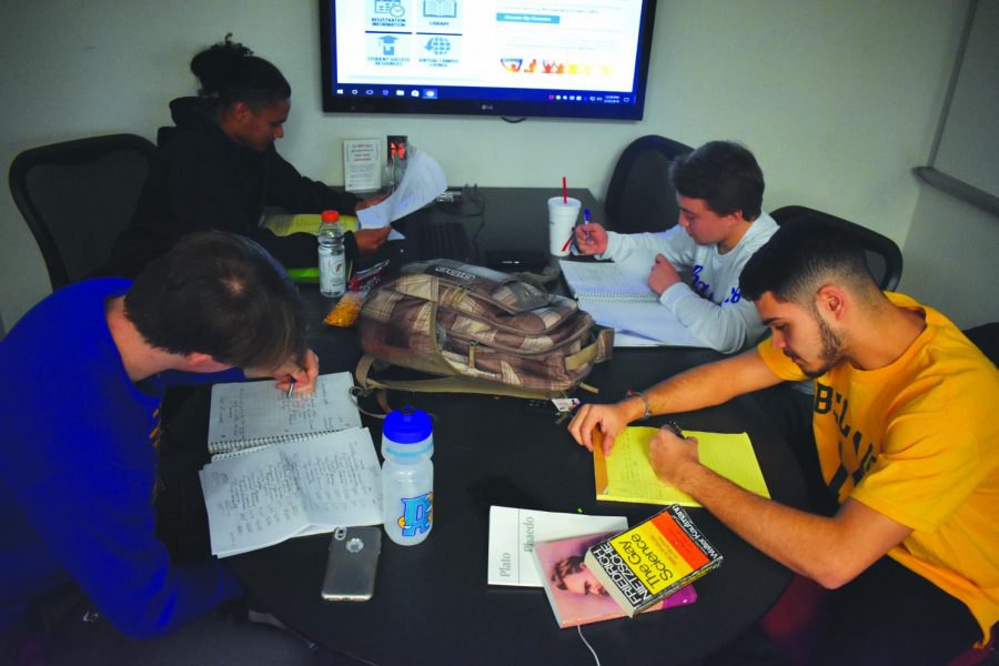 AACC athletes Bret Devine, Joseph Threatt, Zach Burns and Joey Niles study in the Truxal Library.