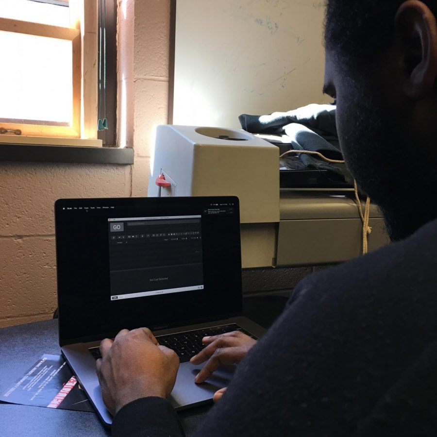 Shawn Smith, a returning game development student, using computer design to help production for Romeo and Juliet.