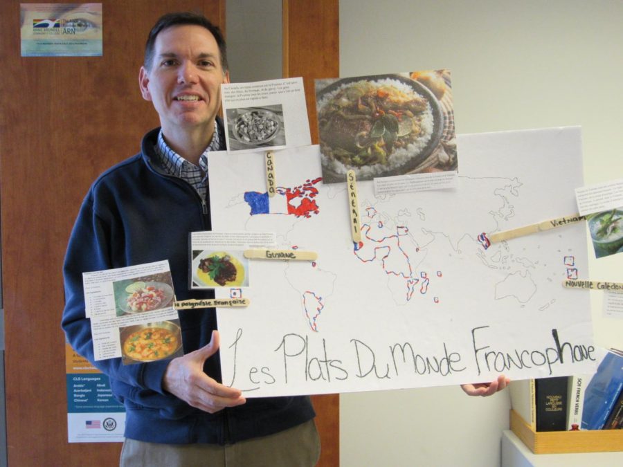 Professor Scott Cooper, World Languages Dept Chair, displays a French poster.