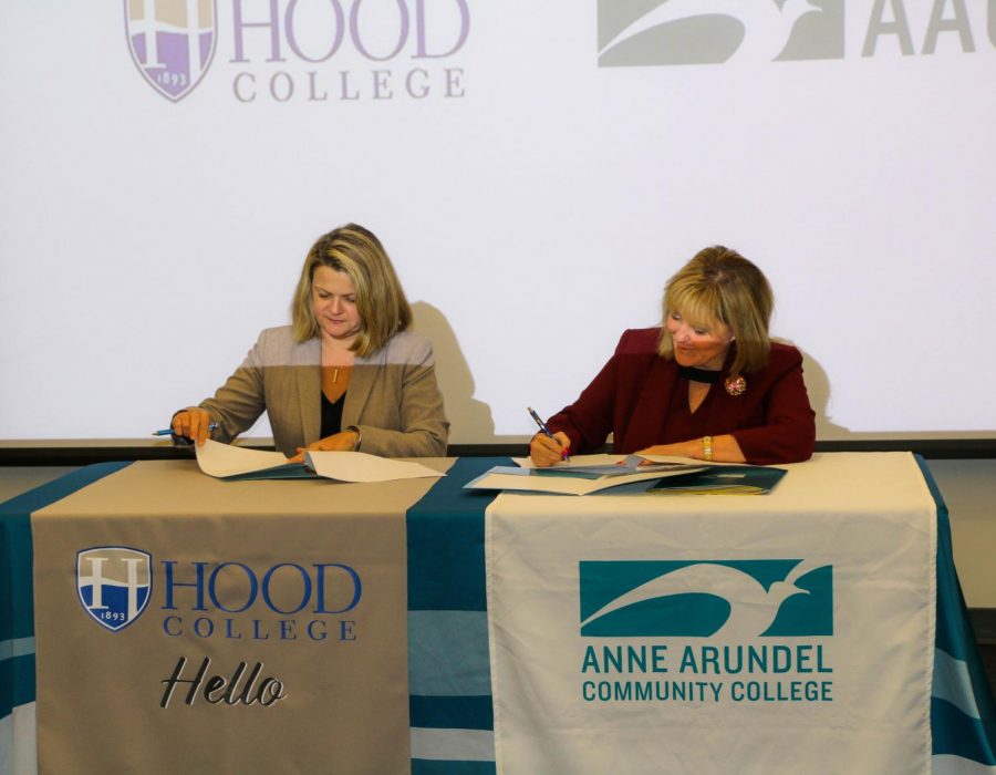 Andrea Chapdelaine, president of Hood College, and AACC President Dawn Lindsay sign a transfer plan.