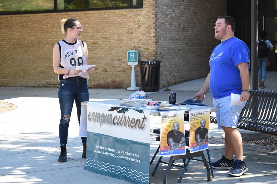 Ren Bishop, a third-year psychology student (left) and Jake Brannon, a second-year transfer studies student advertise the upcoming speech by author Chris Wilson on the quad.