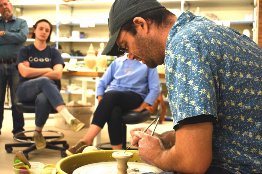 Jason Piccoli gives a demonstration of his technique on a pottery wheel to the students of AACC