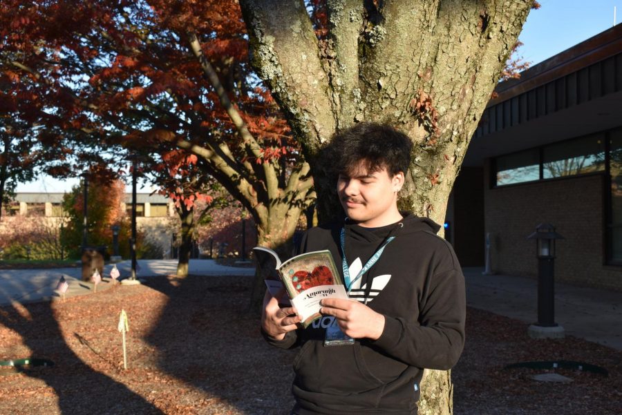 Amaranth Editor-in-Chief Mitchell Santos reads the issue of the literary magazine that won the Pacemaker Award this November. 