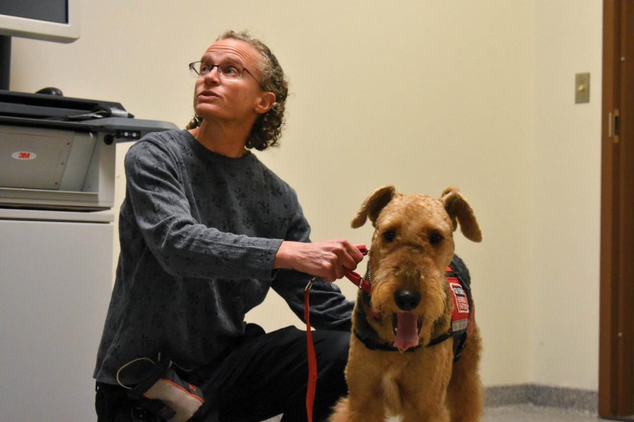 English Professor Jessica Rabin helps her service dog, Caleb, through his airport security training. 