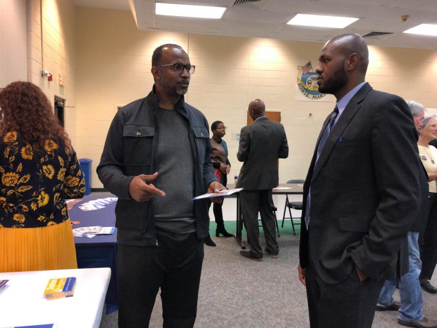 A voter, left, speaks with Darian-Senn-Carter, a professor in AACC's Homeland Security and Criminal Justice Institute who is running for a seat on the Bowie City Council.  