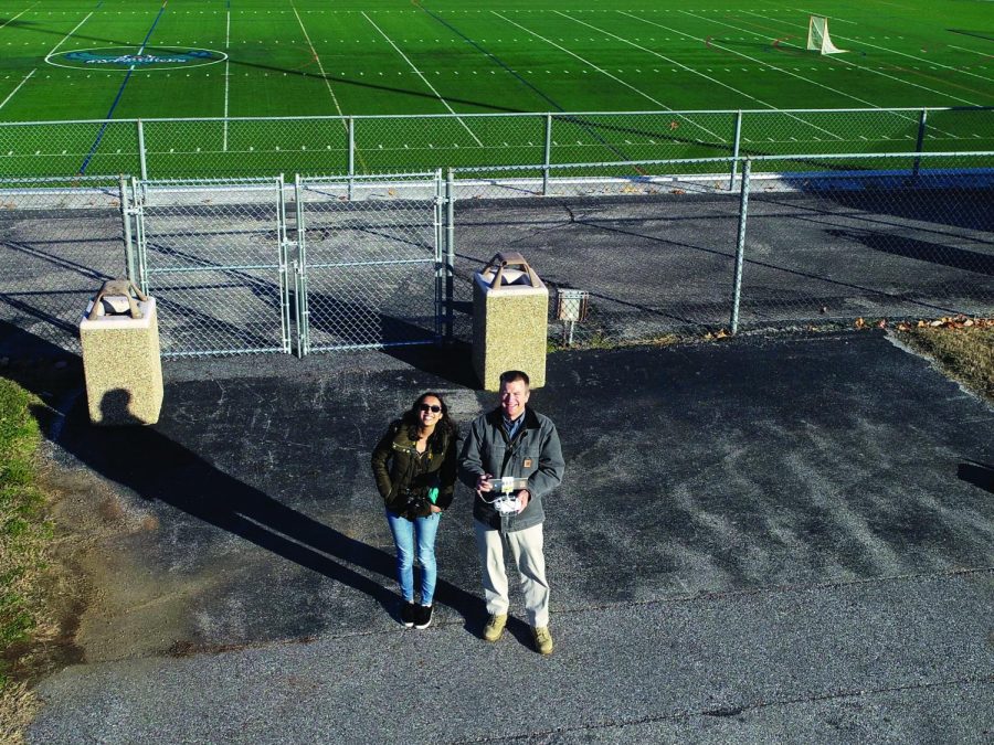 Former Campus Current Editor-in-Chief Amber Nathan watches Tim Tumelty, who is in charge of AACC’s drone program, fly a drone on campus.