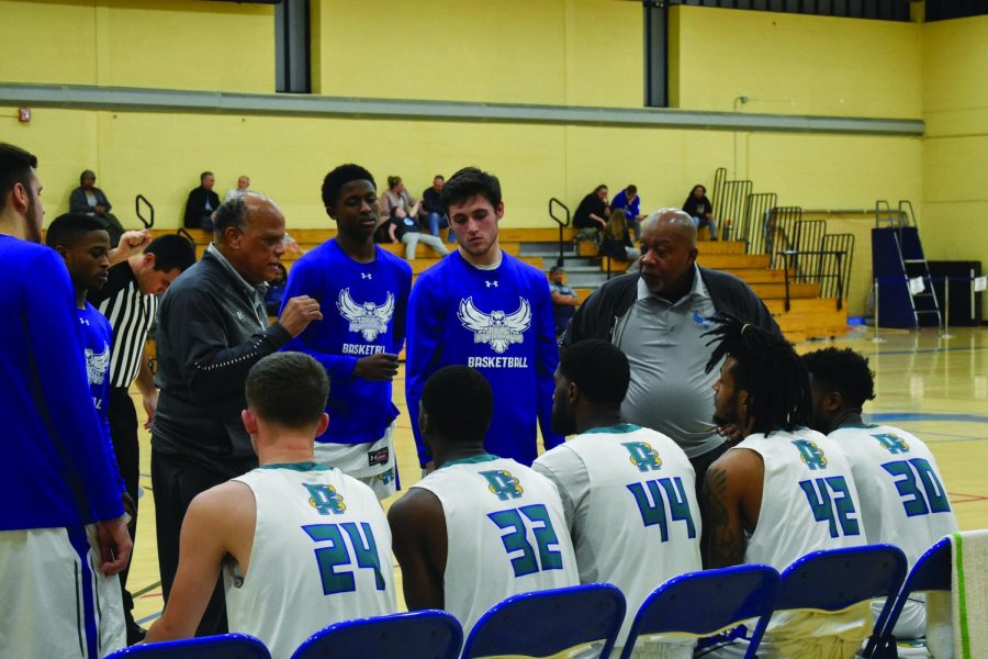 Men’s Basketball coach Joe Snowden (left) speaking during a timeout to forward Michael Sullivan, guard Matthew Kern and assistant coach Joe Gray.