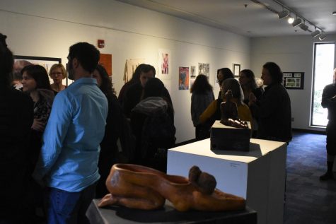 Attendees view pieces at the Art of Women Invitational Exhibit.