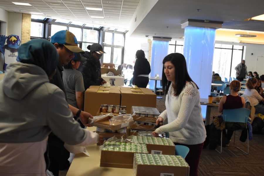 Basic needs coordinator Caitlin Silver handing out canned food to students at the Heart Market.