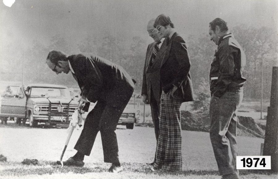 AACC's former Dean of Students William H. Dusman breaks ground in a fall 1974 ceremony marking the beginning of construction on the Student Union building on the college's Arnold campus. With him are  Robert P. Ludlum, AACC’s second president, farthest in the background, and two other college officials.