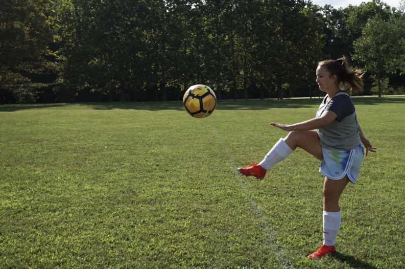 Women's soccer defense/midfield player Sydney Klabnik practices on a grassy field near the baseball diamond while the college replaces the turf at Siegert Stadium.