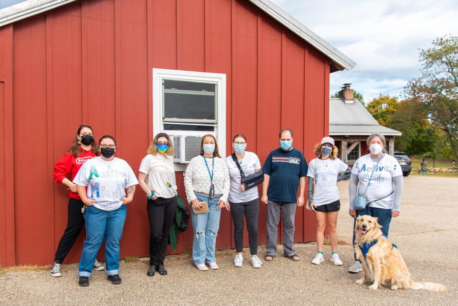 Members and faculty advisers of Active Minds pose at a barn at Kinder Farm Park during a student club event.