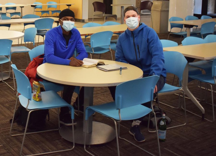 Pals Caleb Lewis, a third-year business administration student (left), and Tommie Parker, a second-year undecided student, read the Bible together in the Student Union’s dining hall.