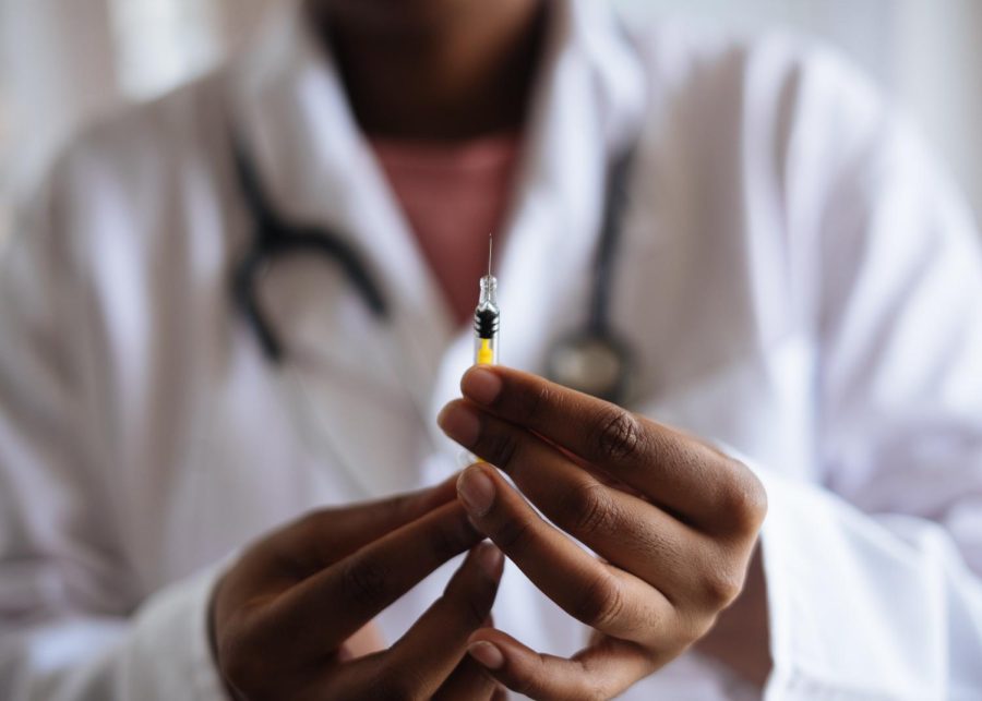 Up close shot of a doctor holding a syringe.