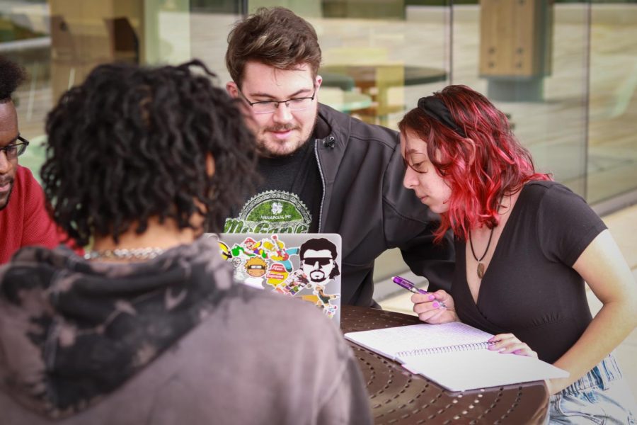 Second-year business student Michael Davis and first-year zoology student Chloe Yates study without masks on campus.