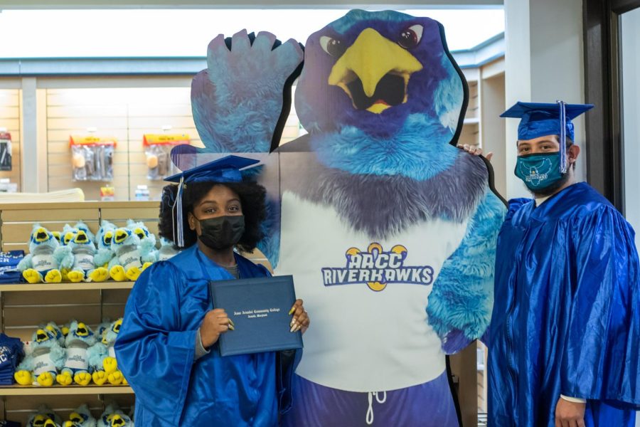 Second-year entrepreneurship student Kaylah Rashid
and second-year information systems student Kevin
Lemus try on their graduation regalia.