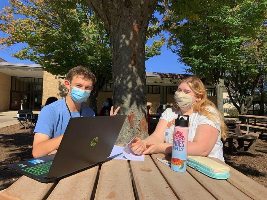 First-year transfer studies students Arnold Beck and
Kestrel Watson mask up on the Quad.