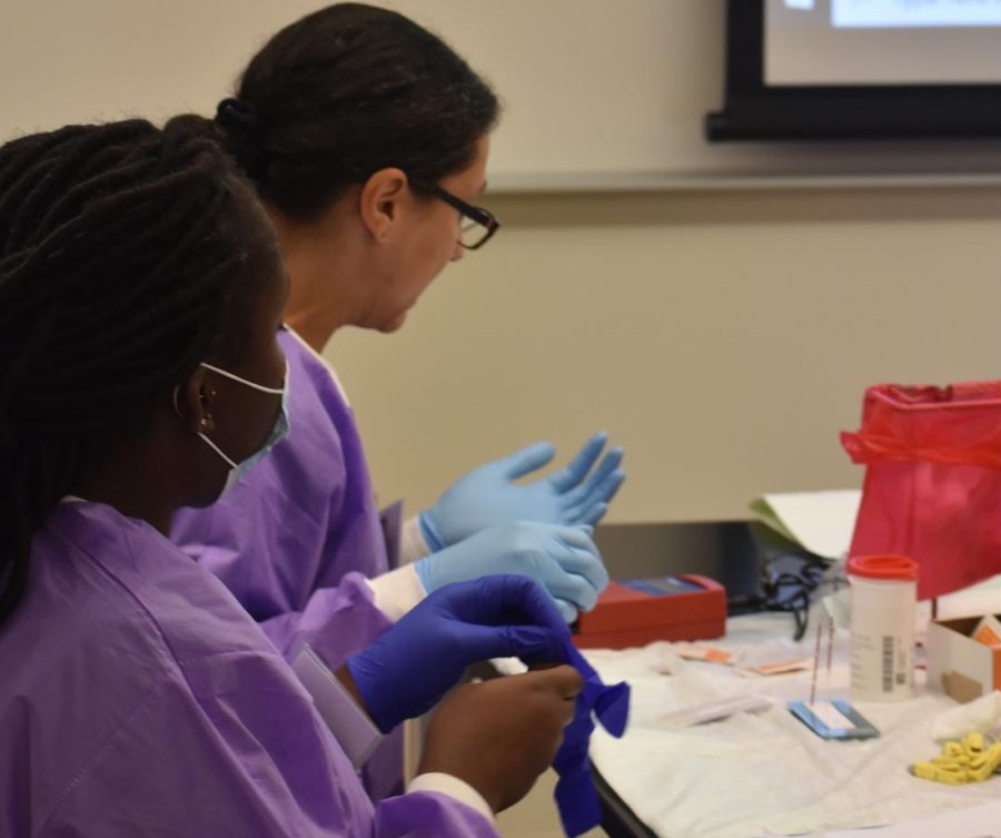 Campus administrators say students and faculty who test positive for monkeypox need to report their results to the college and stay off campus. Shown, medical students put on protective gear during class.