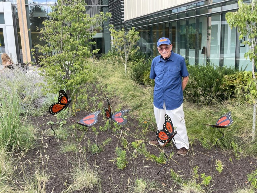 Sculpture student Sergio Alvarez, a retired surgeon, stands outside the Health and Life Sciences building with five statues he created for the new butterfly garden.