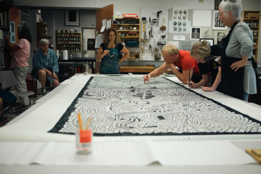 Marta Perez-Garcia works with printmaking professor Chris Mona and AACC students to create the print. 