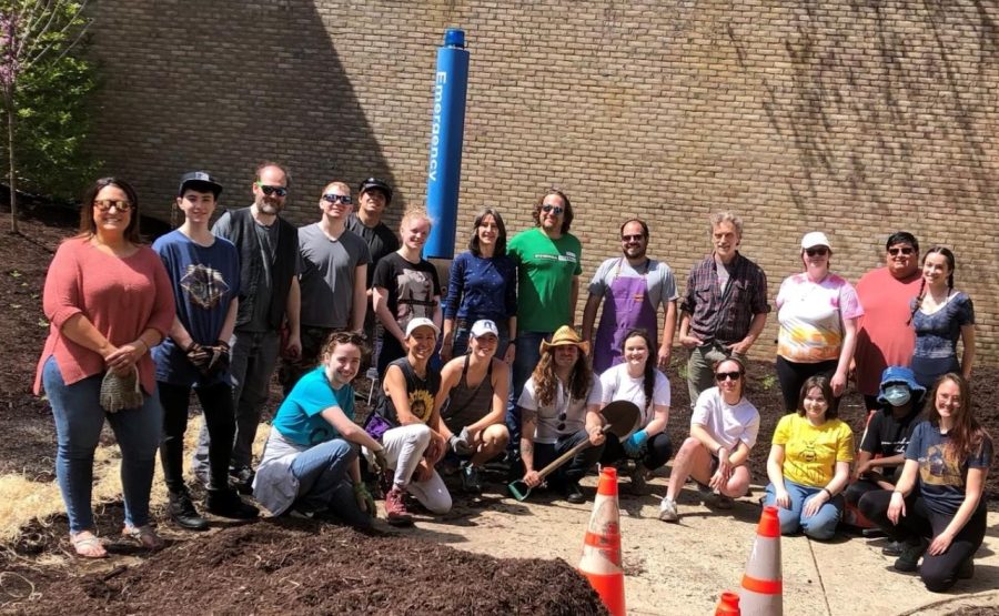 Members of the Super Science Club and the Genders & Sexualities Alliance pose in front of the Pride/Pollinator Garden in April.