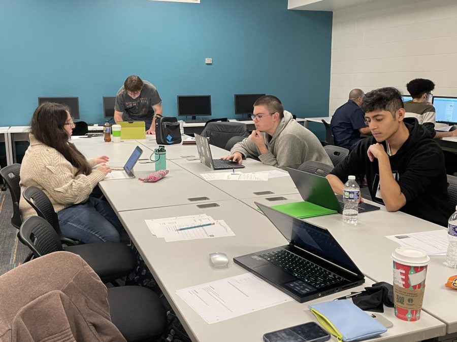 Preliminary data shows an increase in enrollment for the spring semester. Shown, students compare notes in a speech class during the winter semester.