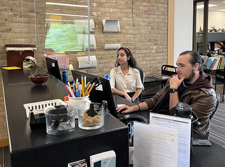 Second-year environmental science student Parinaaz Patel, left, and second-year creative writing student Robert Rogers work at the desk of the Truxal Library.