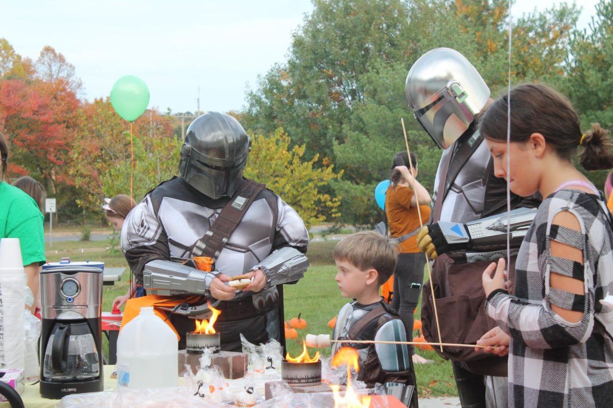 Students dressed in Star Wars Mandalorian costumes roast marshmallows at the AACC Pumpkin Patch event on Friday.