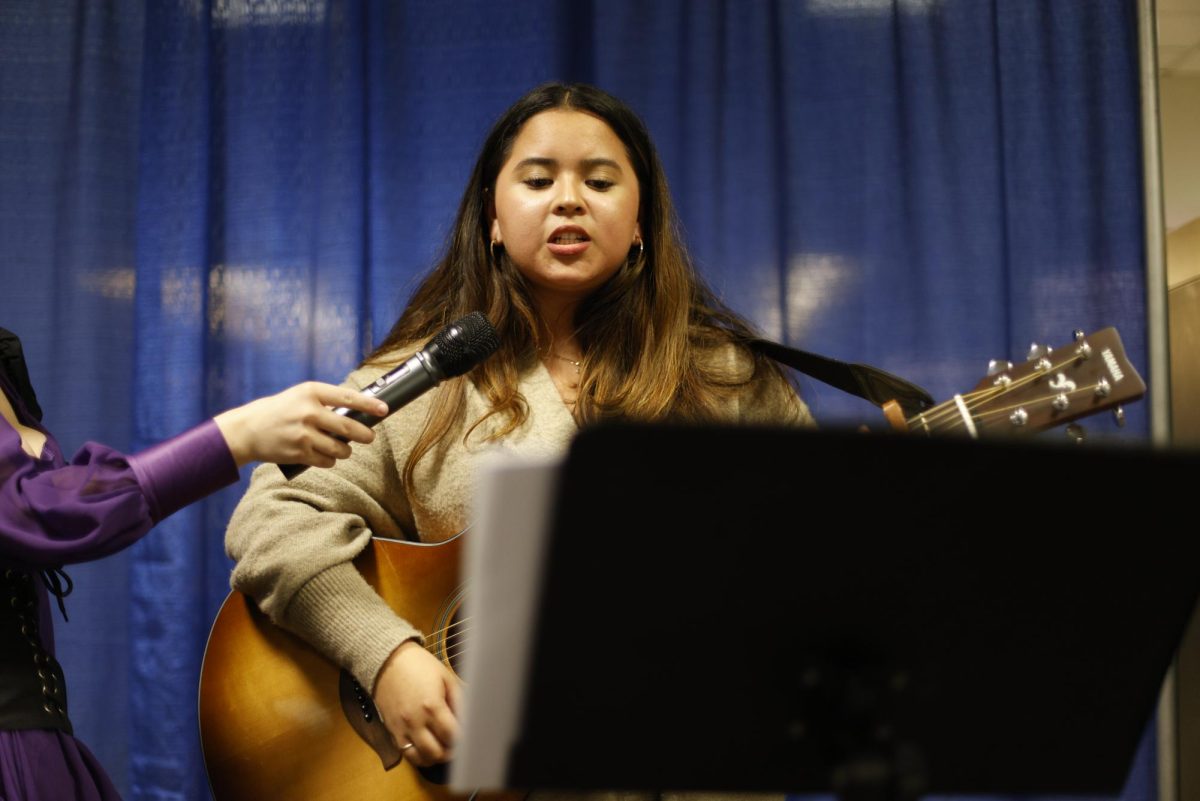 A student performs guitar at Amaranth's open mic night.