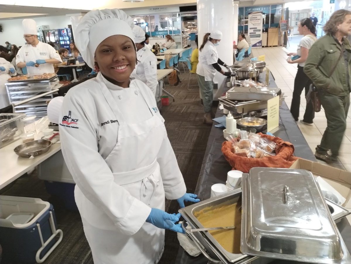 Second-year culinary student Brandi Benton prepares soup to serve to at the Empty Bowls charity event.
