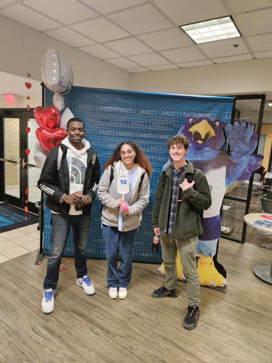 AACC students Jaron Carroll (left), Maria Bejarano (center) and Paul Singleterry get their photo taken at an event.