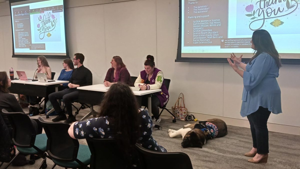 Female AACC students and alumni discuss their research experiences to visitors.