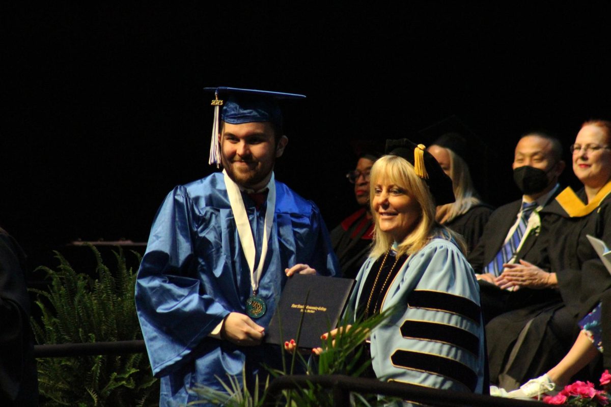 Graduation is a huge accomplishment, but it’s not your only one. Celebrate small wins every day. Shown, AACC President Dawn Lindsay hands a diploma to a graduate.