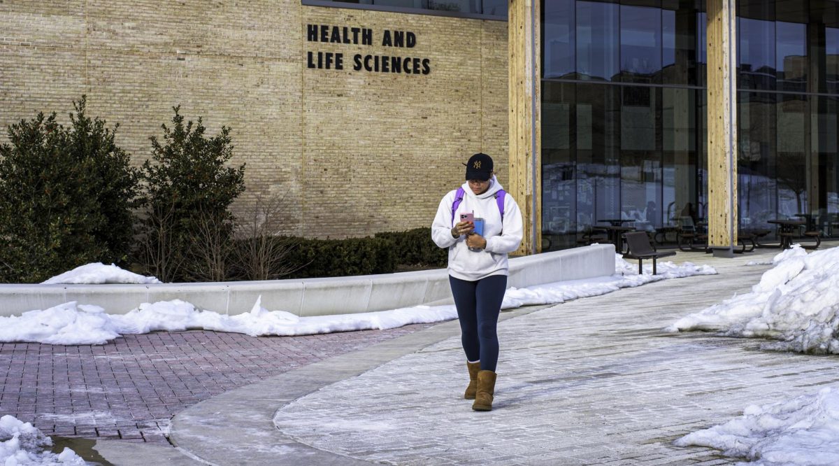 First-year nursing student Michaela West walks on a cleared sidewalk a week after campus closed for five days because of snow.